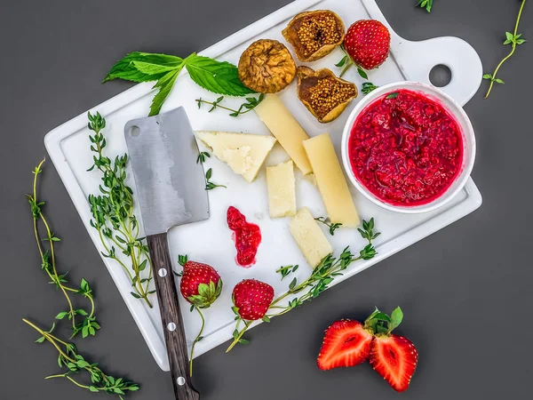 Un conjunto de queso, fresas frescas, hierbas, higos secos y frambuesa — Foto de Stock