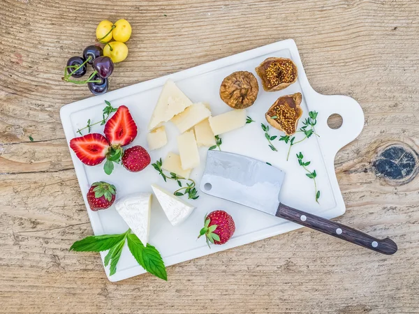 Cheese and fruit set on a wooden desk — Stock Photo, Image