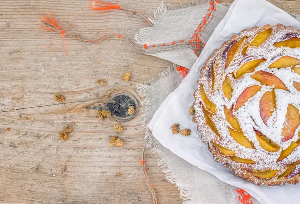 Pfirsichkuchen mit Zuckerpuder über einem Leinentischtuch — Stockfoto