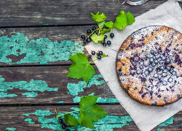 Gâteau au cassis sur la vieille surface en bois peint — Photo