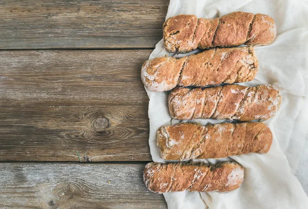 Pan de aldea rústico recién horneado (baguettes) fijado en woo áspero — Foto de Stock