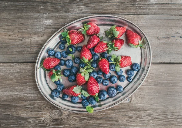 Fresh strawberry and blueberry mix on a metal dish (tray) over a — Stock Photo, Image