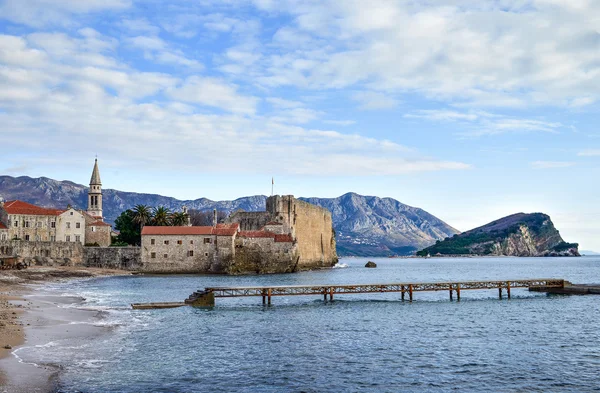 Budva, Montenegro. Praia perto da muralha da cidade velha e fortaleza em Wint — Fotografia de Stock