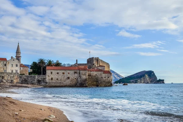 Budva, Montenegro. Praia perto da muralha da cidade velha e fortaleza em Wint — Fotografia de Stock
