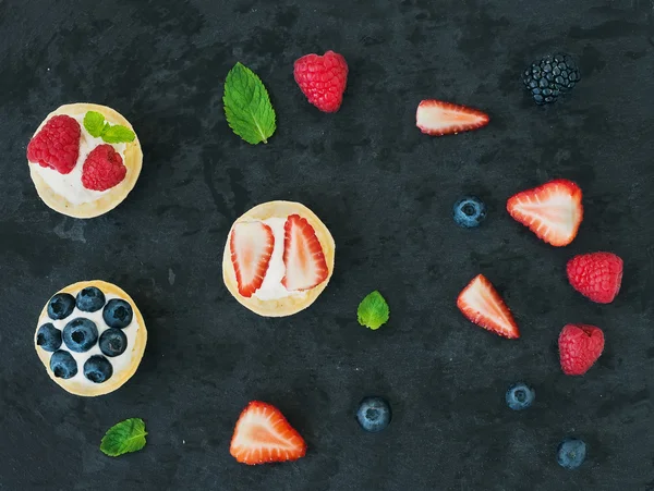 Ягідні та рикоттові тістечка, листя м'яти, полуниці, малини , — стокове фото