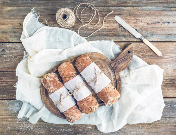 Pão rústico recém-assado (baguetes) embrulhado em papel — Fotografia de Stock