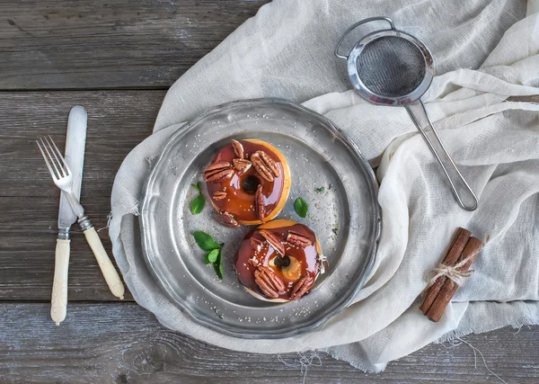 Rosquillas de canela con glaseado de caramelo y pekanes servidos con fresco — Foto de Stock