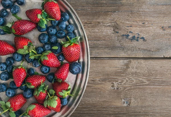 Fresh strawberry and blueberry mix on a metal dish (tray) over a — Stock Photo, Image