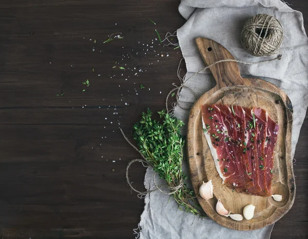 Cured pork meat prosciutto on a rustic woodem board with garli — Stock Image Cured pork meat prosciutto on a rustic woodem board with garli Stock Image