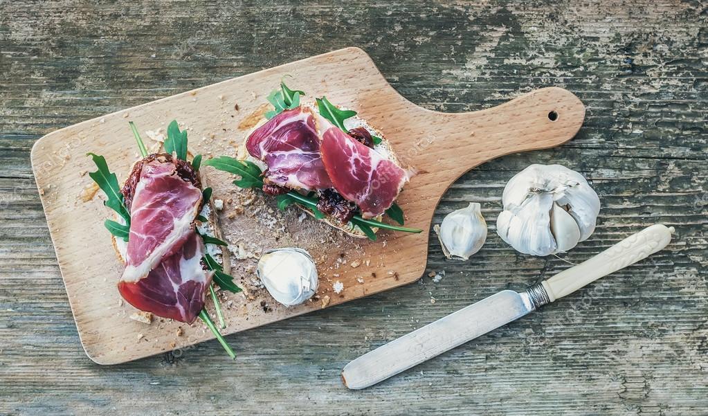 Brushetta üzerinde füme et, roka ve kurutulmuş domates ile ayarla bir