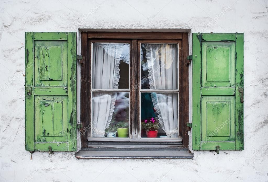 Authentic window with green wooden shuttters in a small town of 