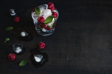 Buz küpleri nane yaprakları ve ahududu cam karanlık grunge yüzeyi ile