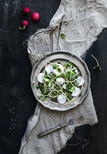 Ensalada de primavera con brotes de girasol y rábano en placa de metal vintage sobre fondo rústico pintado oscuro — Foto de Stock