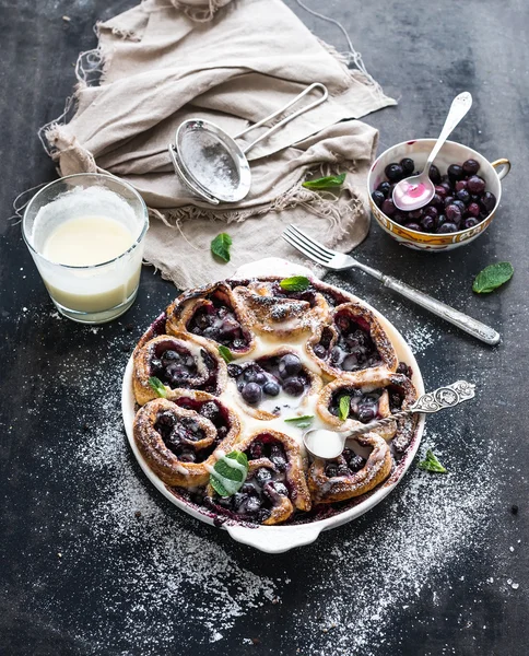 Blueberry buns with fresh mint and creamy sauce on dark backdrop — Stock Photo, Image