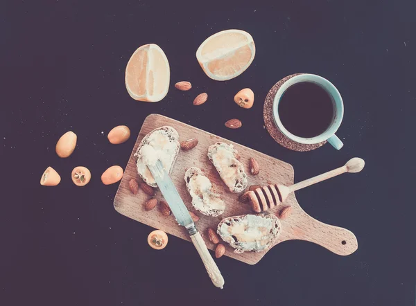 Breakfast set on black backdrop: baguette slices with butter and — Stock Photo, Image