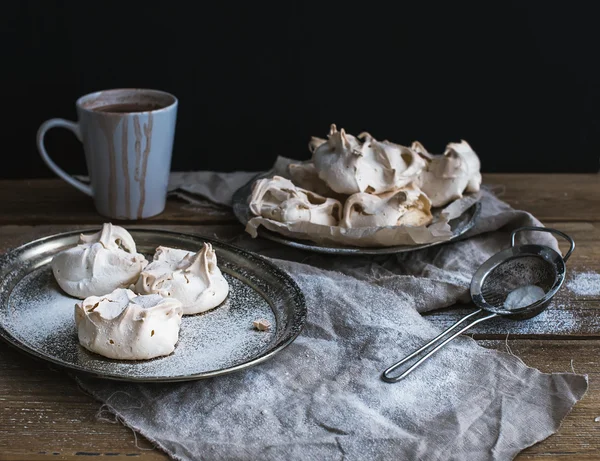 Merengue blanco y taza de chocolate caliente en una mesa de madera rústica. Negro backdro —  Fotos de Stock