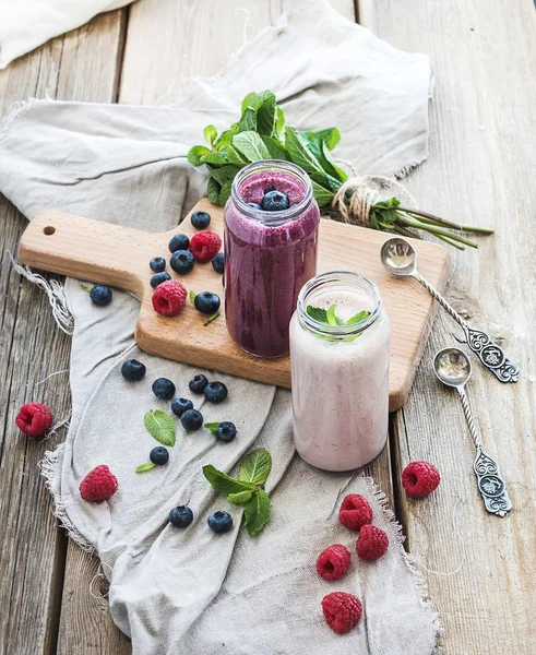 Smoothie saudável fresco com mirtilos, framboesas em frascos de vidro e hortelã — Fotografia de Stock