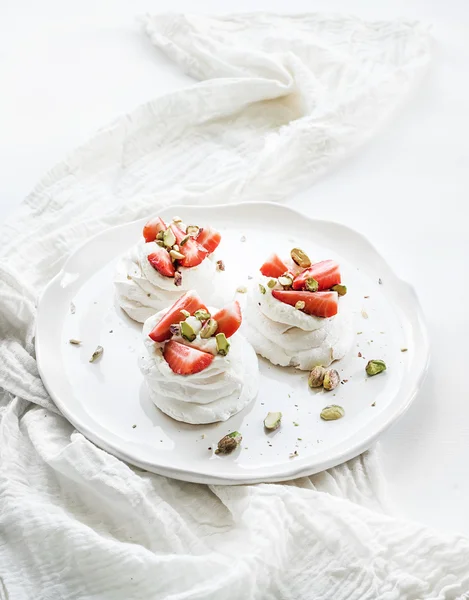 マスカルポーネ クリーム添え、小さなイチゴとピスタチオ ・ パヴロワ メレンゲ ケーキ白の背景の上に新鮮なミント — ストック写真