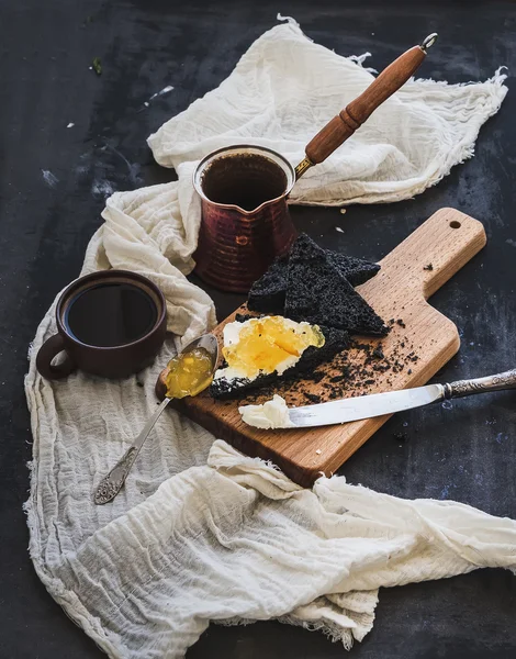 朝食セット。コーヒー、黒は暗いグランジ テーブル表面にクリーム チーズとオレンジのマーマレードで乾杯します。 — ストック写真