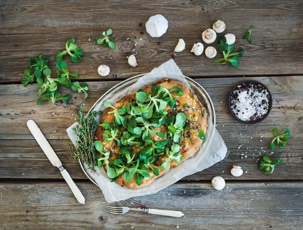 Pizza casera rústica con lechuga fresca de cordero, champiñones y ajo sobre fondo de madera áspera — Foto de Stock