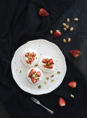 küçük çilek ve fıstık pavlova beze pasta ile mascarpone krema, siyah zemin üzerinde taze nane