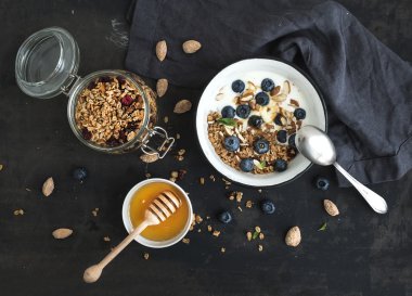 sağlıklı kahvaltı. taze yaban mersini, badem, yoğurt ve nane bir rustik metal kapta yulaf granola