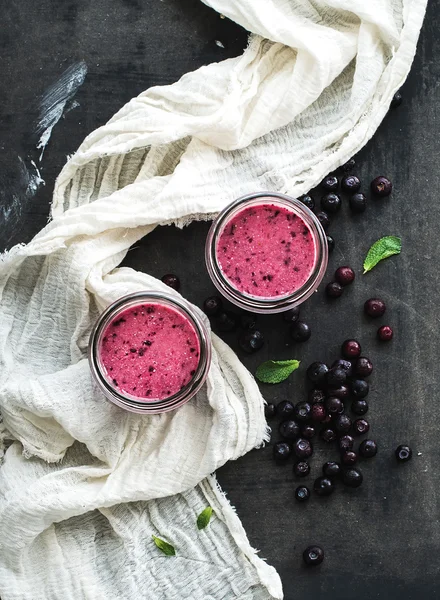 Fresh healthy smoothie in glass jars with blueberries and mint over dark grunge backdrop — Stock Photo, Image