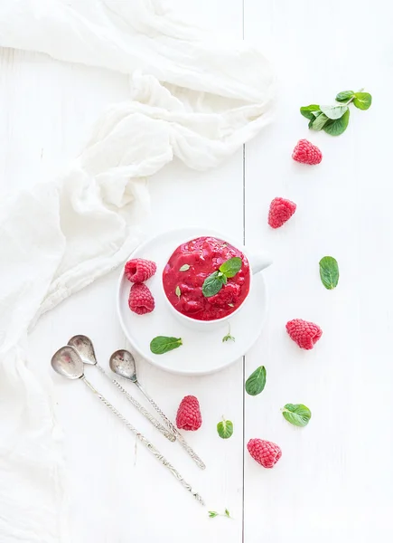 Zmeură sorbet înghețată cu frunze de mentă și linguri pe fundal alb — Fotografie, imagine de stoc