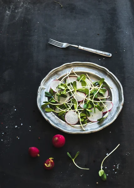 Frühlingssalat mit Sonnenblumenkohl und Rettich in Vintage-Metallteller über rustikalem dunkel bemaltem Hintergrund — Stockfoto