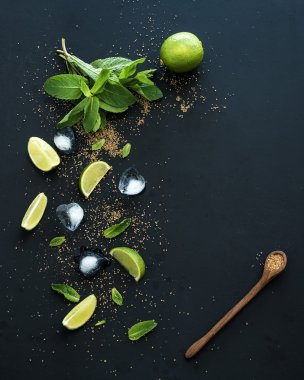 Mojito için malzemeler. Taze nane, limon, buz, siyah zemin üzerinde şeker. Üstten Görünüm.