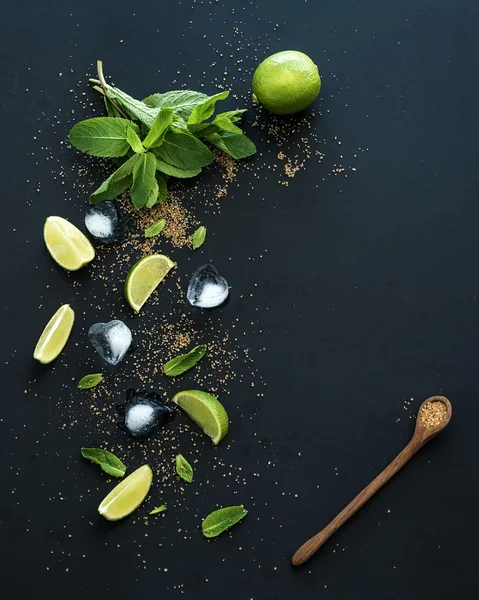 Ingredientes para mojito. Hortelã fresca, limas, gelo, açúcar no fundo preto. Vista superior . — Fotografia de Stock