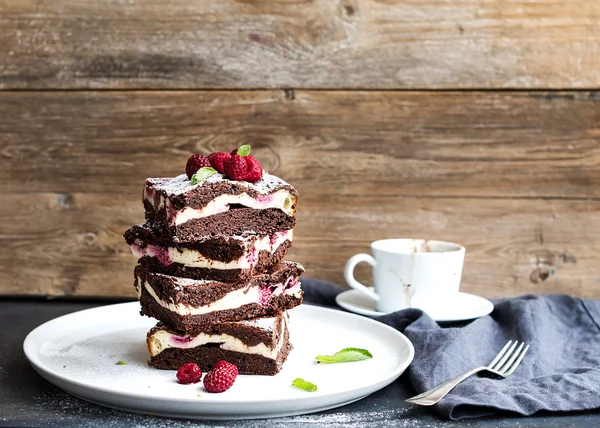 Brownies-cheesecake tower with raspberries on white plate, wooden backdrop, copy space — Φωτογραφία Αρχείου