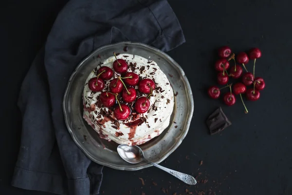 Pavlova tårta med färska körsbär, ost grädde och choklad chips i vintage silver plattan över mörk grunge bakgrund, ovanifrån — Stockfoto