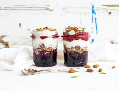 Yoğurt yulaf granola çilek, bal ve fındık Cam Kavanoz, rustik beyaz arka plan ile