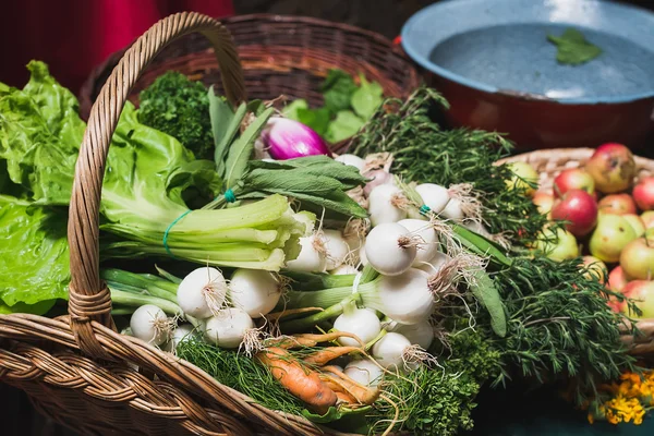 Fresh vegetables and herbs in rustic basket at Sunday market — Stok fotoğraf