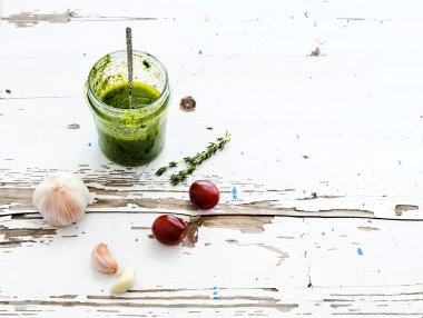 Taze ev yapımı pesto sarımsak, domates ve kekik rustik Beyaz ahşap zemin üzerinde kavanoz. Üstten Görünüm 