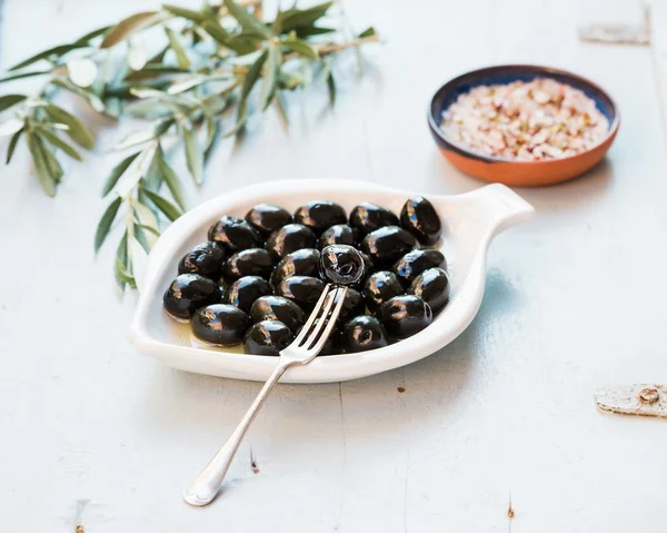 Aceitunas negras en plato de cerámica blanca — Foto de Stock