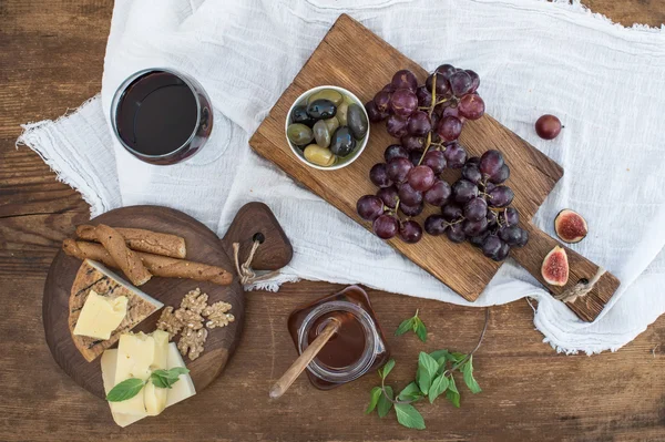 Copo de vinho tinto, placa de queijo, uvas — Fotografia de Stock