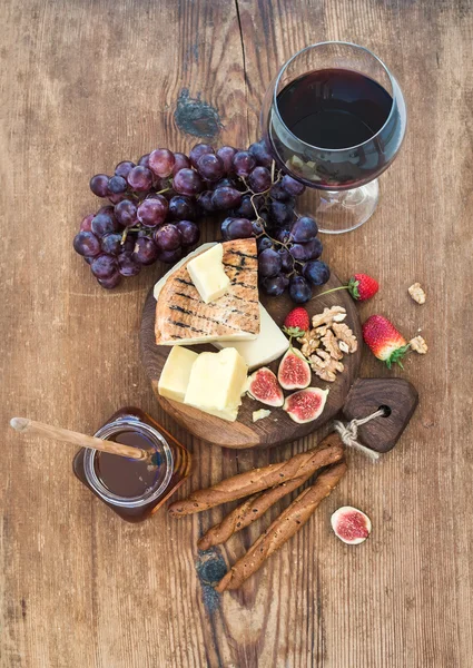 Glass of red wine, cheese board — Stock Photo, Image