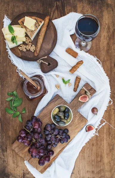 Glass of red wine, cheese board — Stock Photo, Image