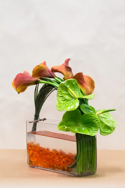 Arregaço floral com lírios Calla, antúrio e vegetação — Fotografia de Stock