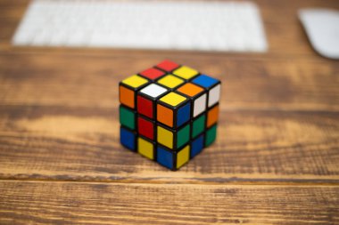 Renkli 3B kombinasyon Rubik küpü 3 'er 3' er tahta bir masada yatıyor.