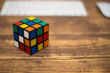 Renkli 3B kombinasyon Rubik küpü 3 'er 3' er tahta bir masada yatıyor.