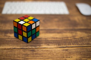 Renkli 3B kombinasyon Rubik küpü 3 'er 3' er tahta bir masada yatıyor.