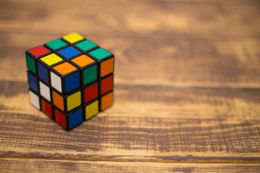 Renkli 3B kombinasyon Rubik küpü 3 'er 3' er tahta bir masada yatıyor.