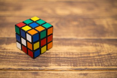 Renkli 3B kombinasyon Rubik küpü 3 'er 3' er tahta bir masada yatıyor.