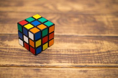 Renkli 3B kombinasyon Rubik küpü 3 'er 3' er tahta bir masada yatıyor.