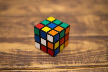 Renkli 3B kombinasyon Rubik küpü 3 'er 3' er tahta bir masada yatıyor.