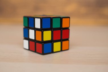Renkli 3B kombinasyon Rubik küpü 3 'er 3' er tahta bir masada yatıyor.
