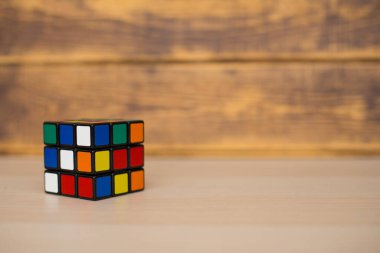 Renkli 3B kombinasyon Rubik küpü 3 'er 3' er tahta bir masada yatıyor.